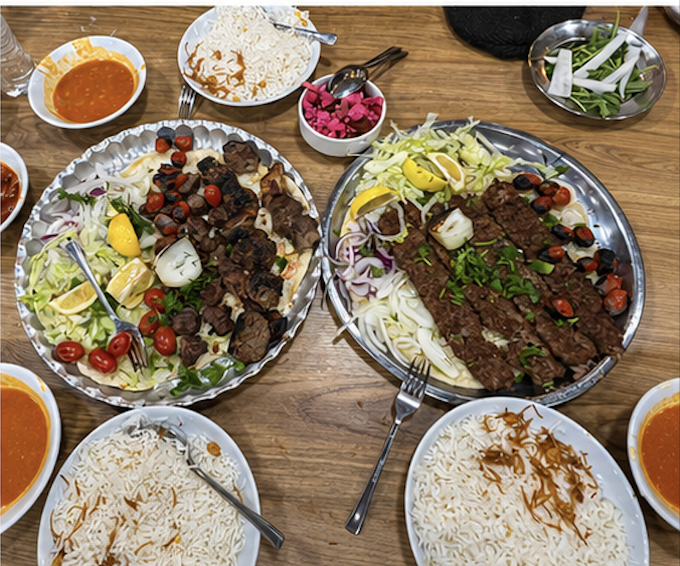 A full Kurdish table spread — kebabs, lamb skewers, rice and salads