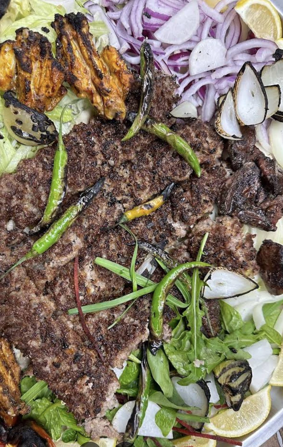 Long kebab platter with grilled tomatoes and salad